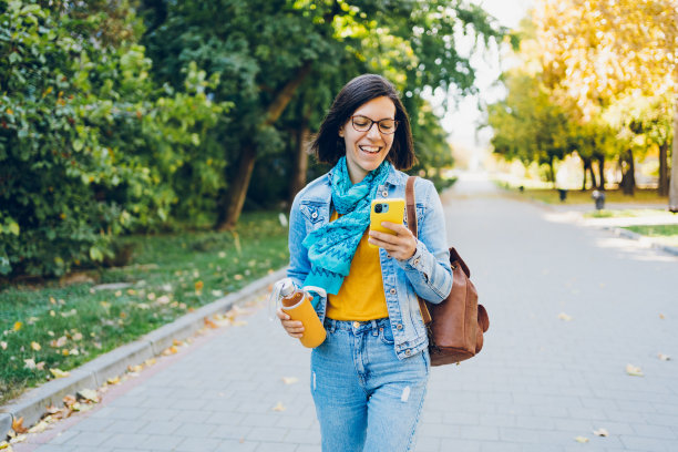 一个女人用手机在城市里走动图片下载