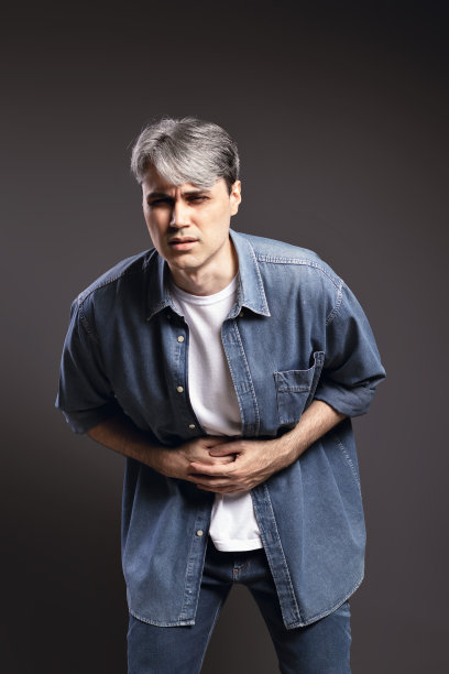 一个巴西男人的肖像，穿着纽扣衬衫和牛仔裤，他的手在他的肚子上，在痛苦，与灰色的头发-彩色照片-巴西图片下载