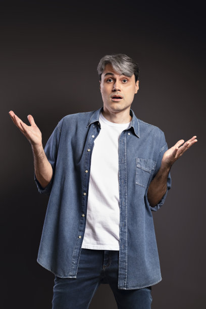 一个巴西人的肖像穿着纽扣衬衫和牛仔裤，惊讶，张开双臂和灰色的头发-彩色照片-巴西图片下载