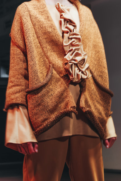 女性形象在棕色舒适温暖的裤子和针织橙色毛衣。图片下载