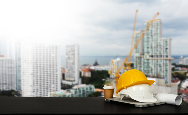 建筑房屋和建筑。修复工作。Dof笔记本电脑和办公室建筑在桌子上的办公室模糊背景。建筑师的概念。图片下载