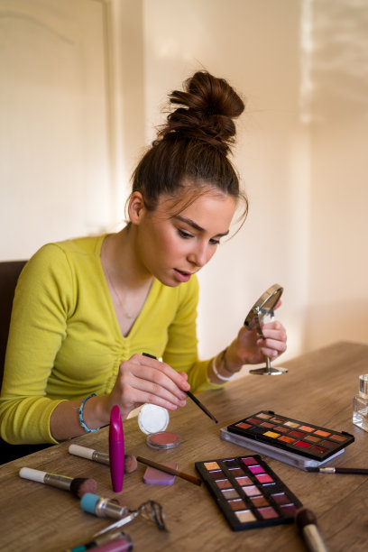 年轻女子在家里化妆。图片下载