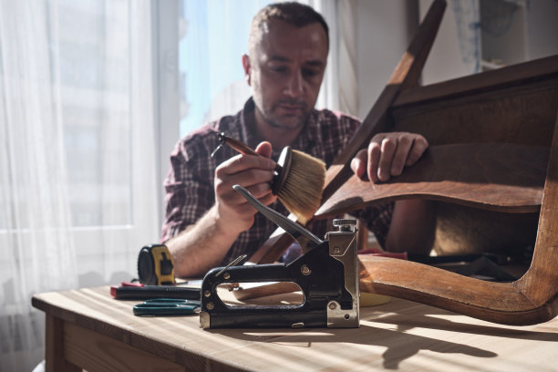 一名男子在一间小型家庭作坊从事家具修理和修复工作。图片下载