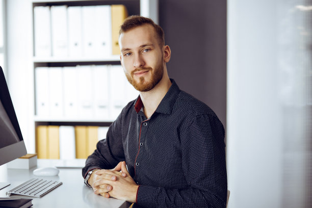 红胡子友好的成年商人看着相机。商务头像或肖像在阳光明媚的办公室图片下载