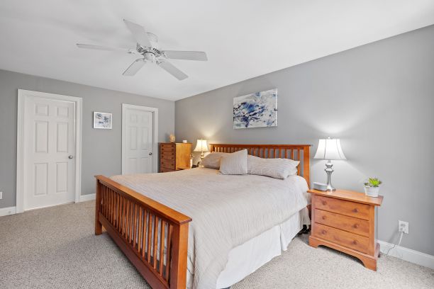 舒适的卧室内部，配有一张单人床，梳妆台和吊扇图片下载