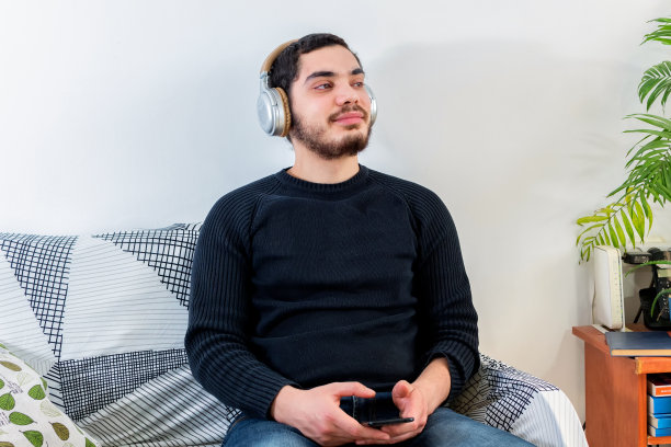 一名年轻的白人男子正在用无线耳机听音乐图片下载