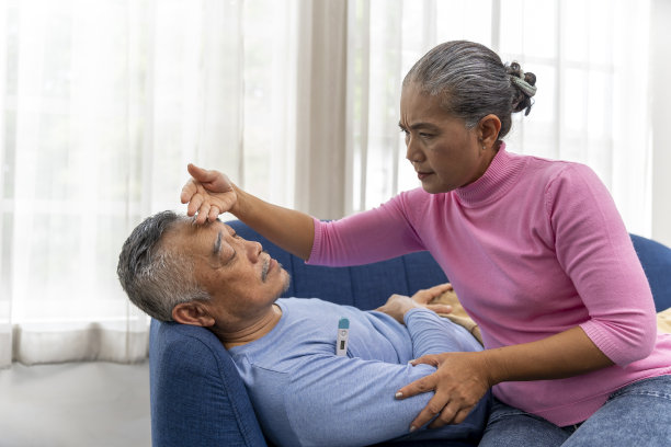 关怀老人的女人看着她丈夫的体温温度计图片下载