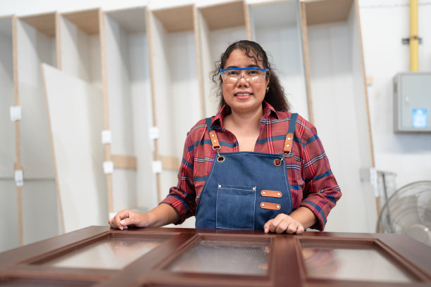 肖像亚洲女木匠与木材厂的木门工作图片下载