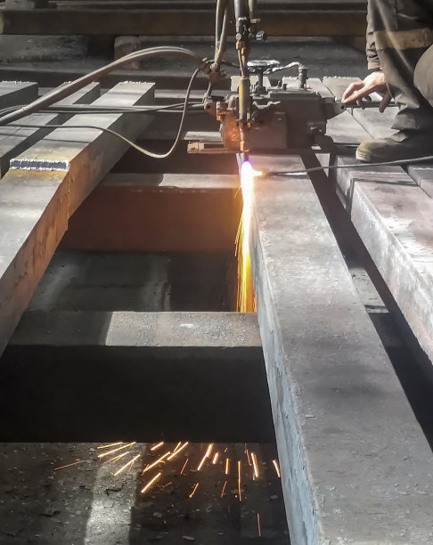 冶金厂-金属加工。在加工和分类前切割一个正方形。工厂的钢铁生产。工件由气割机加工。图片下载