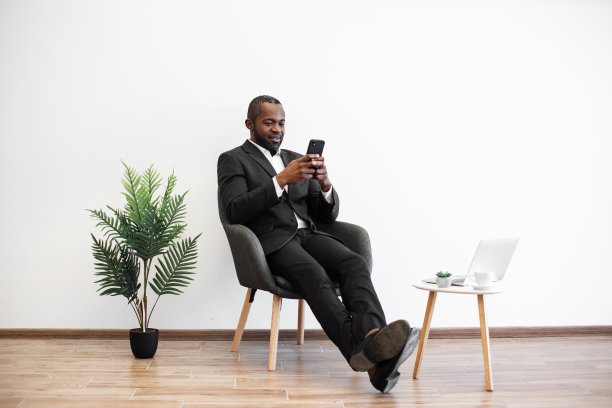 带着智能手机和笔记本电脑的商人坐在室内图片下载