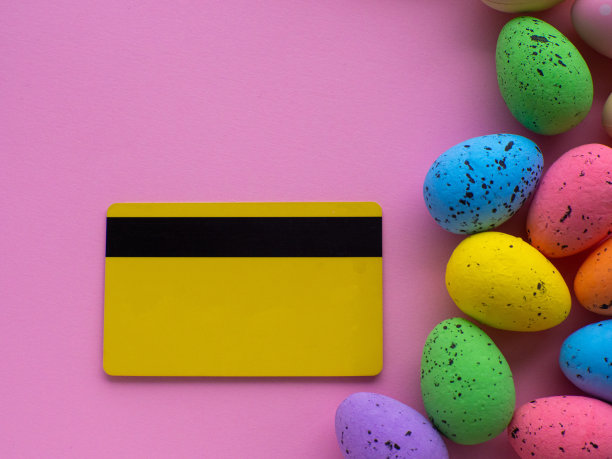 购物车与彩色鸡蛋，信用卡在粉红色背景与复制空间图片下载