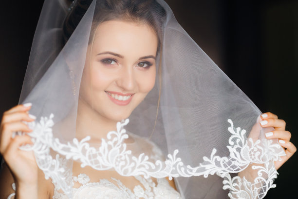 新娘用面纱蒙住脸，望向天空图片下载