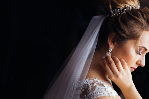 侧面新娘与婚纱和白色礼服。女孩修耳朵图片下载