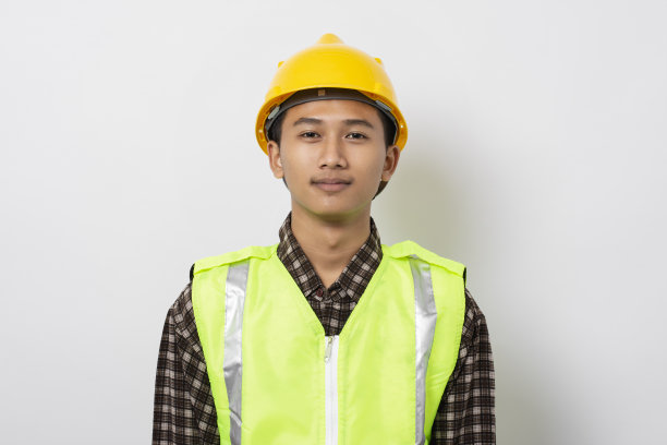 微笑的年轻亚洲建筑工人孤立在白色背景的肖像图片下载