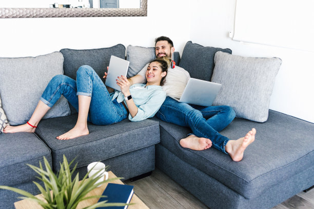 年轻的拉丁夫妇在墨西哥的家里用笔记本电脑和耳机工作，西班牙人的家庭办公室图片下载