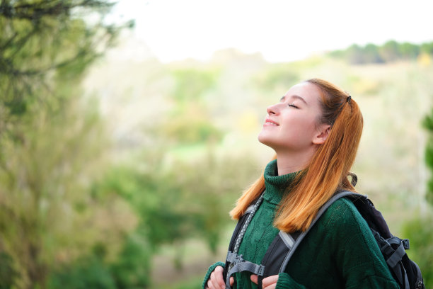 女徒步旅行者在山上呼吸新鲜空气。图片下载