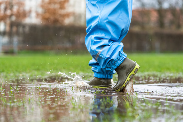 在一个水坑前的公园里，一个小孩的剪影图片下载