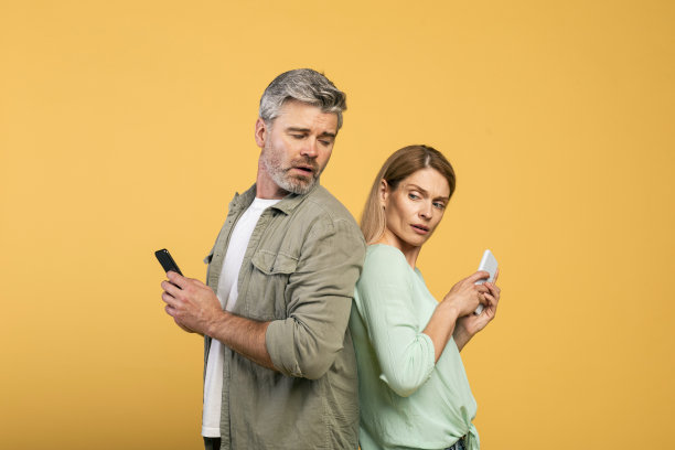 隐私的概念。中年白人男子试图看他妻子的智能手机，女人隐藏她的电子设备的屏幕图片下载