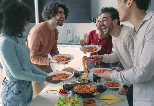 午餐时，一名男子在餐厅为他的朋友们提供意大利面。图片下载