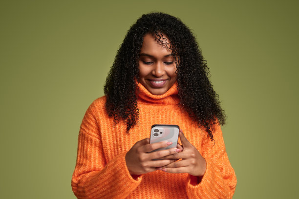 开朗的少数民族妇女在工作室使用智能手机图片下载