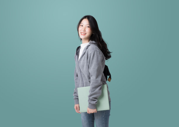 年轻的亚洲女大学生平板电脑和背包孤立在蓝绿色背景图片下载