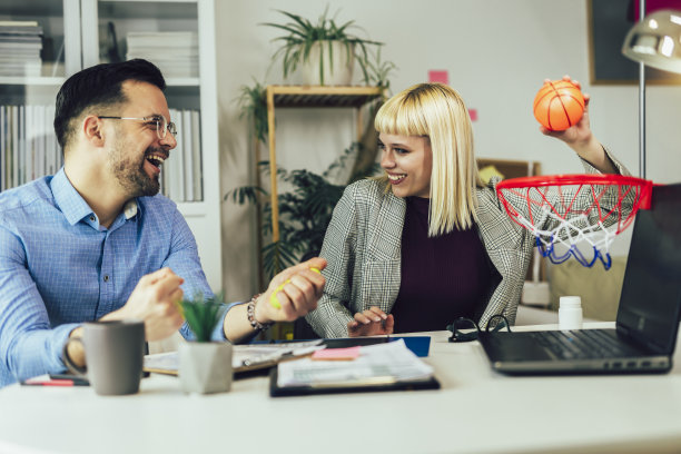 年轻的商务人士在家庭办公室一起工作，玩篮球。图片下载