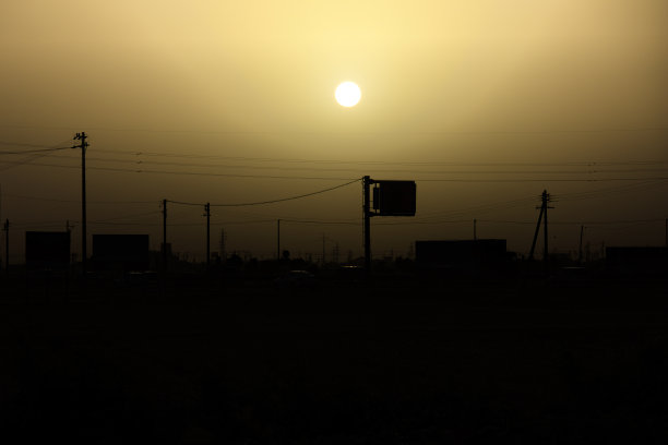 黄色朦胧的天空，黄色的灰尘和剪影的电线环境污染图片下载