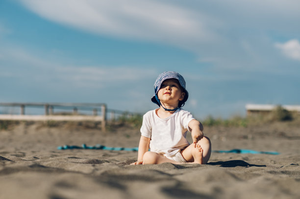 可爱的蹒跚学步的孩子男孩在沙滩上玩沙图片下载