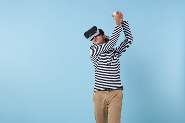 亚洲男子在虚拟现实中玩游戏。活跃的年轻人戴着虚拟现实眼镜打高尔夫。运动的年轻人探索沉浸式虚拟现实游戏。图片下载