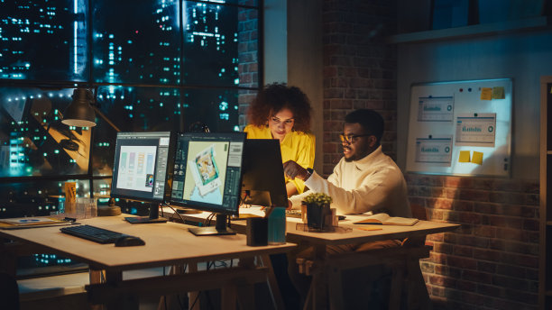 两个富有创造力的多元文化同事在一个项目上合作，并作为一个团队一起工作。女性CEO和设计师谈论和讨论营销活动的变化。晚上工作。图片下载