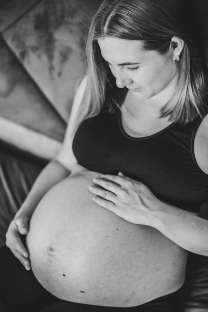 怀孕的女人。黑白照片。怀孕，母性，生育概念。女人的腹部特写。雌性等待新生婴儿。怀孕的姑娘抱着肚子，牵挂着健康。前视图。图片下载