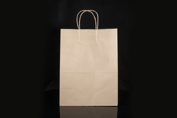 可回收的工艺纸袋购物，礼物和外卖食物模拟黑色背景。比一次性塑料袋更环保图片下载
