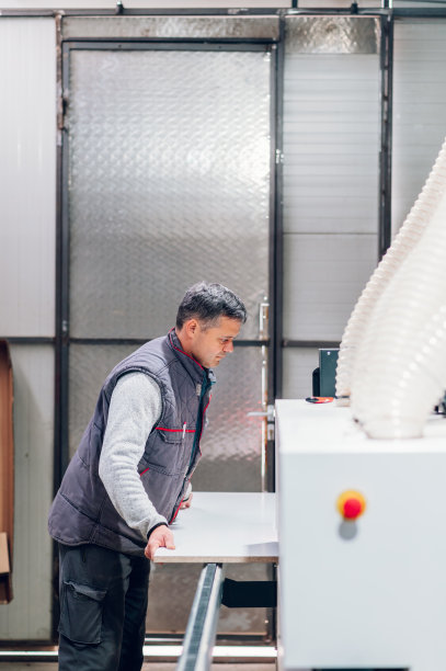 一名木工正在车间的木材加工机上制作家具。图片下载