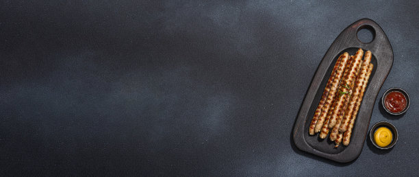 木板烤猪肉香肠。一套酱汁，野餐或烧烤的传统食物图片下载