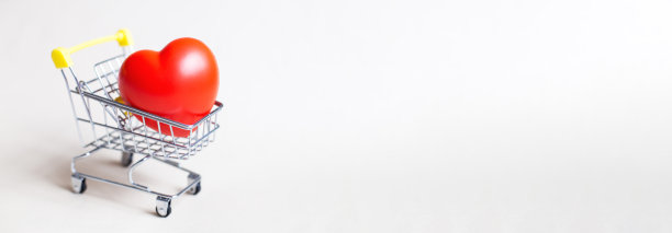 红心在购物车或手推车孤立的米色背景。图片下载