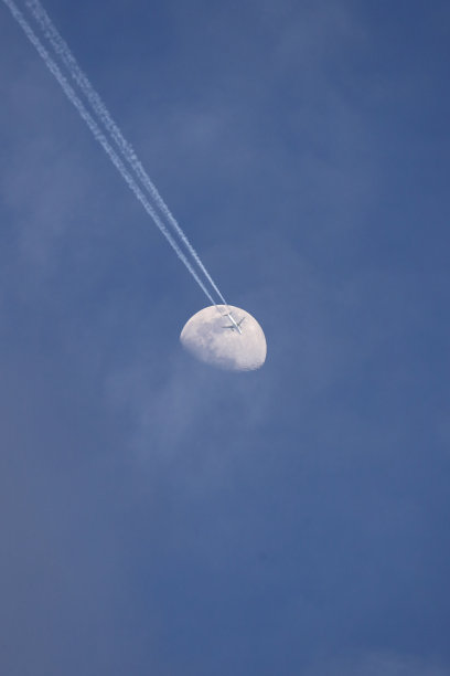 一架喷气式飞机在满月下飞行在夜晚，彩色图像图片下载