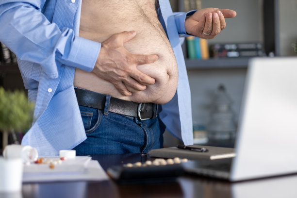 成年超重男子抱着他的肚子图片下载