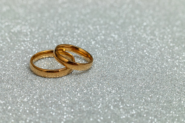 嫁给我好吗?两个金色的结婚戒指在银光闪闪的背景。订婚求婚婚礼概念。情人节明信片。情人节的横幅。副本的空间。图片下载