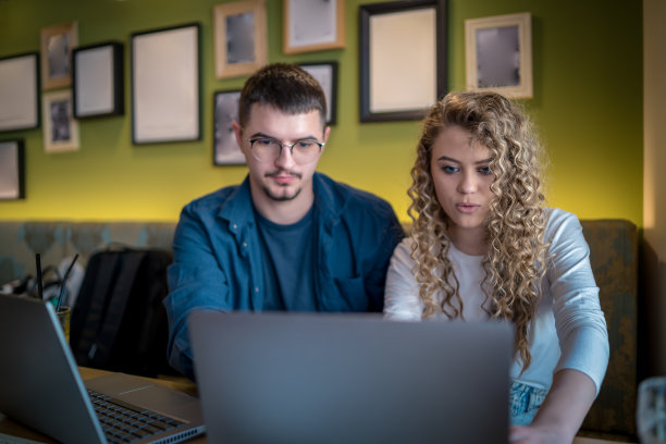 Business people working together at a café using their laptops图片下载