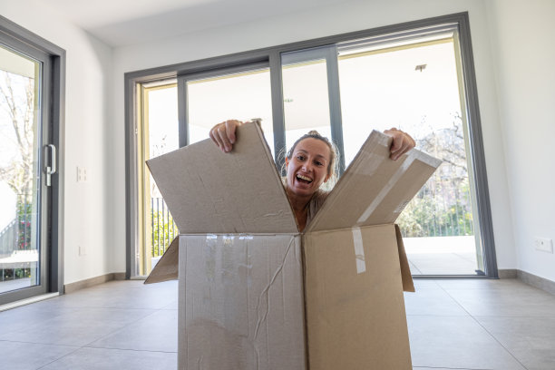 有趣的时刻，女人搬家从纸板箱里出来了图片下载