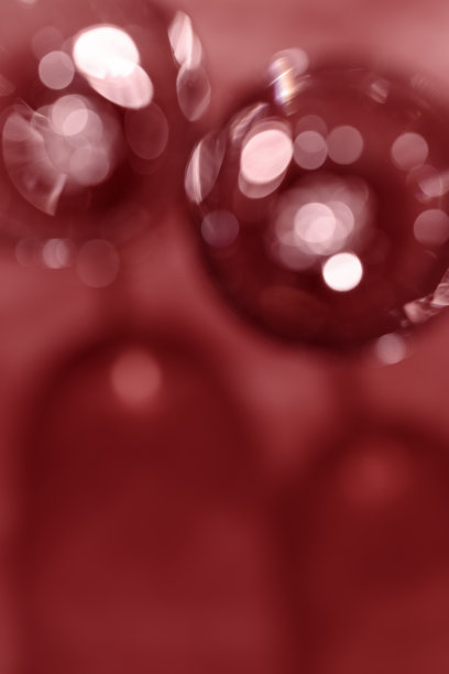 酒杯的红酒作为模糊的背景，抽象的红酒色背景，自然的光影和阴影，眩光和闪光的散景纹理，栗色的墙纸唯美。节日的概念图片下载