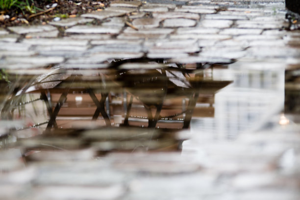 桌椅倒映在雨中的水坑里图片下载