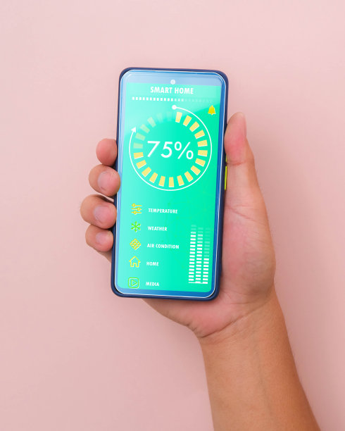 男性手持智能手机，粉色背景，智能手机应用程序屏幕上的智能家居技术界面。自动化的概念。图片下载