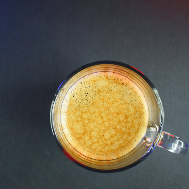 黑色的桌子上有霓虹灯，热腾腾的黑咖啡图片下载