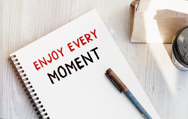 记事本上刻有“赚更多钱”字样。咖啡纸杯，早餐纸袋放在桌上。从上面看。市场营销的概念。图片下载