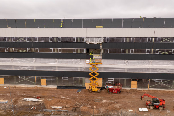 无人机拍摄的施工现场和施工工人在春季阴天完成施工工作。图片下载