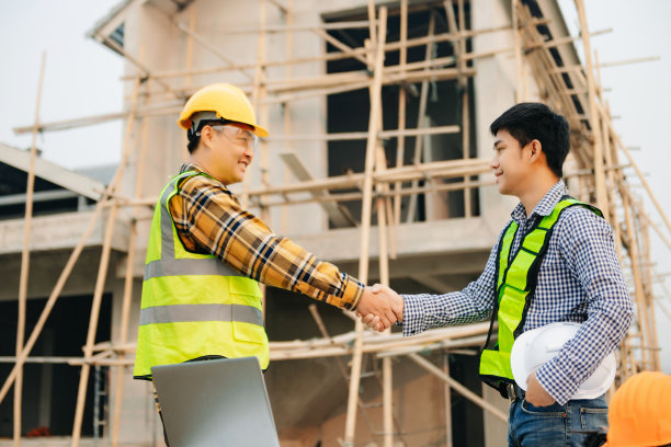工程师和承包商签订合同后携手合作，共同进行一个现代化的建筑工程。成功的合作理念图片下载