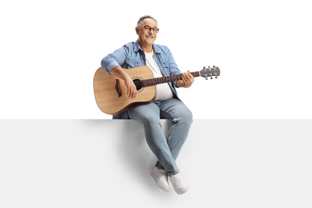 坐在面板上弹奏原声吉他的成熟男人的全身像图片下载