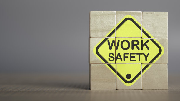安全生产理念。工作安全文本在木制立方体和副本规格。安全第一标志在虚拟屏幕上。危害、保护、法规和保险，零事故，保护危险。图片下载