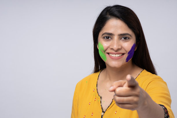 年轻的印度聪明的女孩与海鸥颜色的节日彩粉工作室拍摄图片下载